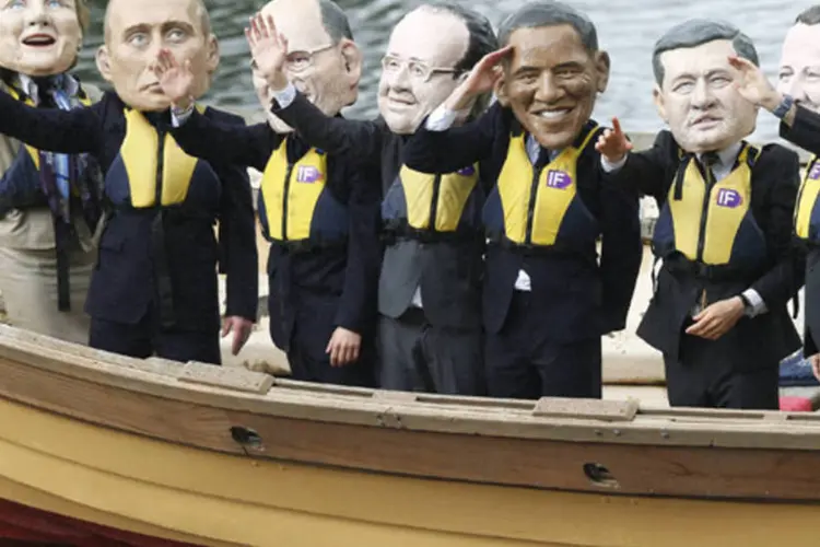 Ativistas usando máscaras gigantes com os rostos dos líderes do G8 chegam em réplica de barco Viking durante protesto contra a cúpula do G8, em Enniskillen, na Irlanda do Norte (Andrew Winning/Reuters)