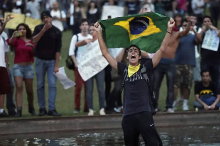 
	Manifestante exibe bandeira nacional durante protesto contra os gastos da Copa das Confedera&ccedil;&otilde;es
 (Ueslei Marcelino/Reuters)