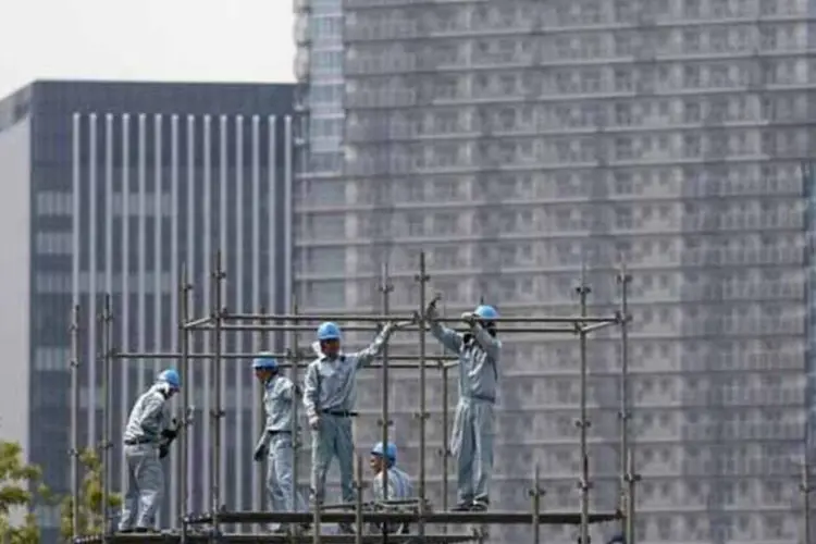 Pessoas trabalhando na construção de um arranha-céu em Tóquio, no Japão (Issei Kato/Reuters)