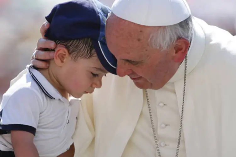 Papa Francisco abraça uma criança ao chegar para sua audiência semanal na Praça de São Pedro, no Vaticano (Stefano Rellandini/Reuters)