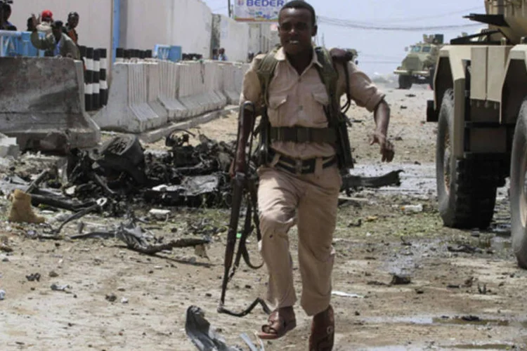 Soldado do governo somali corre para se esconder durante tiroteio depois que homens armados atacaram um complexo das Nações Unidas na capital da Somália, Mogadíscio (Omar Faruk/Reuters)