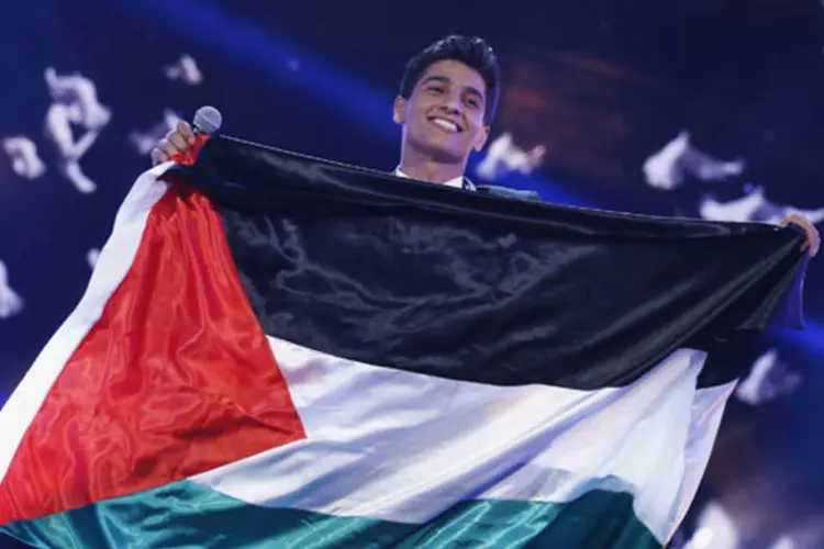 Cantor palestino Mohammed Assaf segura a bandeira da Palestina enquanto espera nos bastidores ser anunciado como vencedor do "Arab Idol", no norte de Beirute, no Líbano (Mohammed Azakir/Reuters)