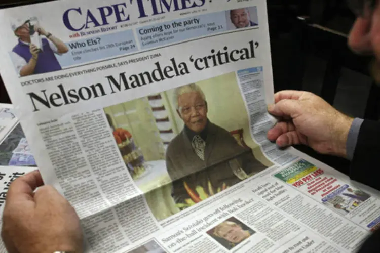 Homem lê jornal em Cape Town com a notícia do estado de saúde do ex-presidente Nelson Mandela na capa (Mark Wessels/Reuters)