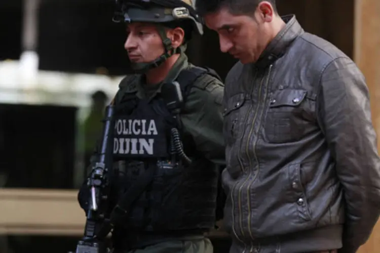 Policial colombiano com Edgar Murillo, que junto com outros 5 colombianos foi condenado pelo assassinato do agente norte-americano James "Terry" Watson, em Bogotá (John Vizcaino/Reuters)
