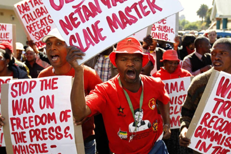 Manifestantes carregam cartazes em um protesto contra a visita do presidente dos Estados Unidos, Barack Obama, em Pretória, África do Sul (Siphiwe Sibeko/Reuters)