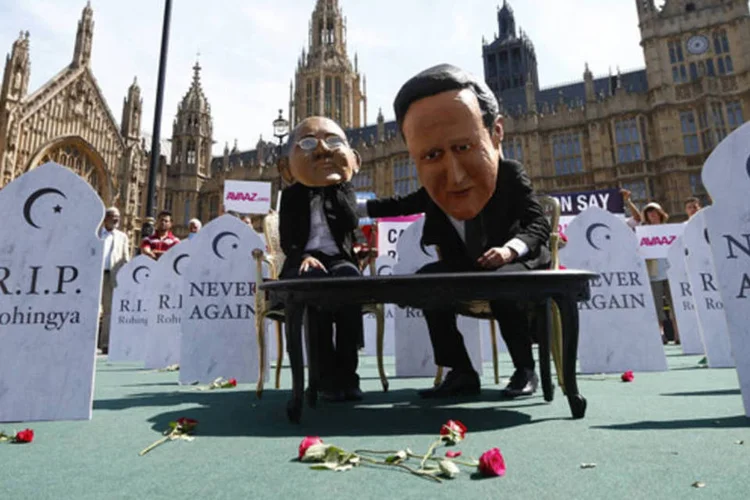 Manifestantes posam para fotos com máscaras do primeiro-ministro britânico, David Cameron, e do presidente de Mianmar, Thein Sain, do lado de fora da Casa do Parlamento, em Londres (Andrew Winning/Reuters)