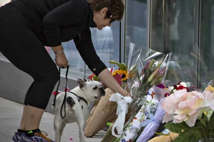 Mulher deixa flores em um pequeno memorial para o ator canadense Cory Monteith do lado de fora do Hotel Fairmont Pacific Rim, em Vancouver (Andy Clark/Reuters)