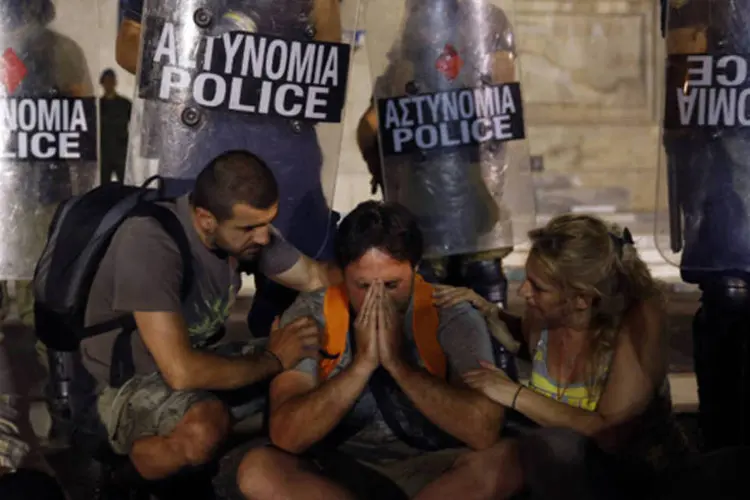 Trabalhador público é consolado após Parlamento aprovar medidas de austeridade em Atenas, na Grécia (Yannis Behrakis/Reuters)