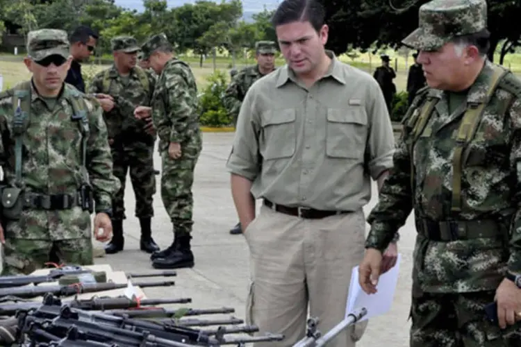 Ministro da Defesa da Colômbia, Juan Carlos Pinzon, e o general do exército Alejandro Navas inspecionam as armas apreendidas da FARC em uma base militar na cidade de Tame (Filiberto Guarnizo/Divulgação via Reuters)