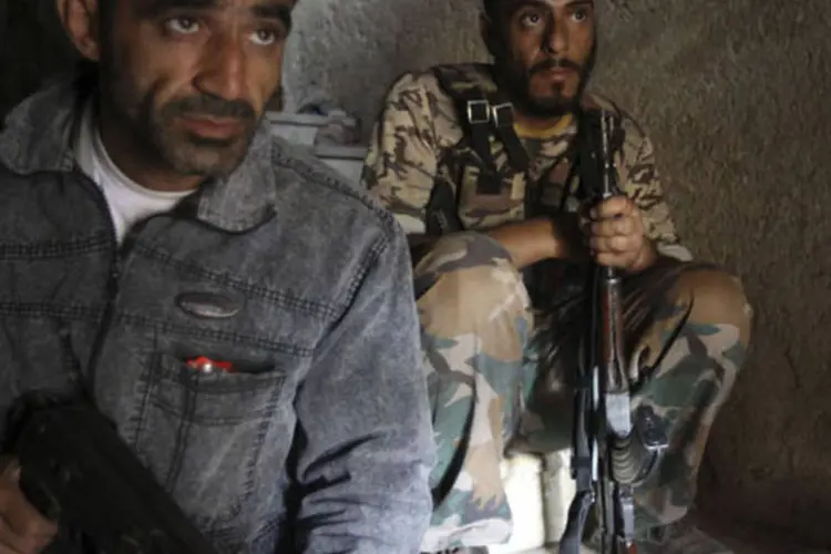 Soldados do exército livre da Síria montam guarda em uma construção na cidade de Alepo, na Síria (Muzaffar Salman/Reuters)