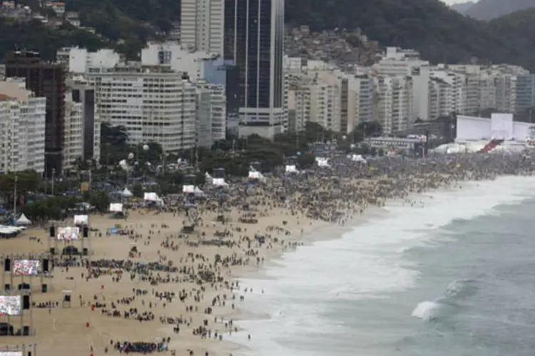 
	Antes da chegada dos s&iacute;mbolos, uma multid&atilde;o esperava nas areias de Copacabana assistindo shows de m&uacute;sica cat&oacute;lica e rezando
 (Stefano Rellandini/Reuters)