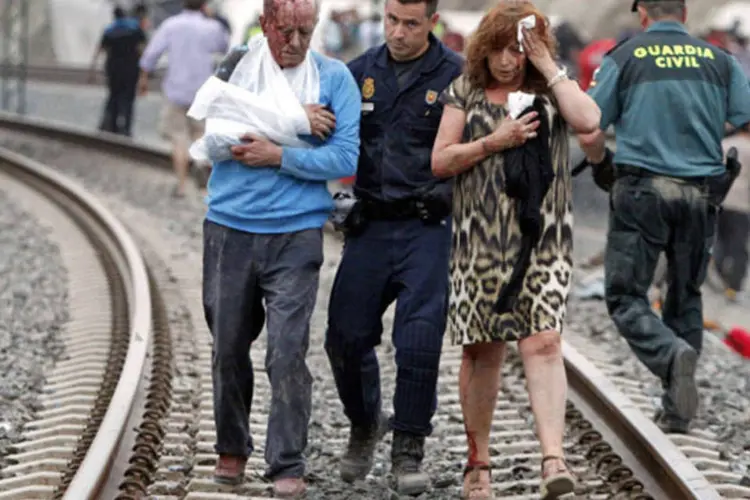 Equipes de resgate ajudam vítima do descarrilamento de um trem próximo da cidade de Santiago de Compostela, na Espanha (Xoan A. Soler/Monica Ferreiros/La Voz de Galicia/Reuters)