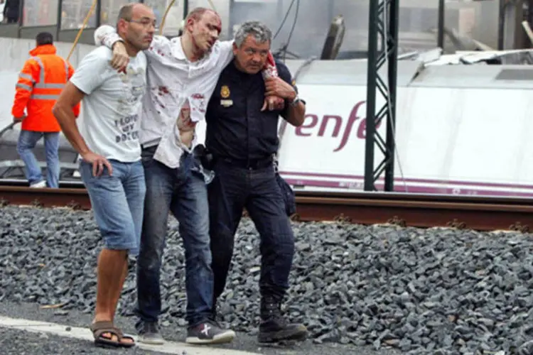 Equipes de resgate ajudam vítima do descarrilamento de um trem próximo da cidade de Santiago de Compostela, na Espanha (Monica Ferreiros/La Voz de Galicia/Reuters)