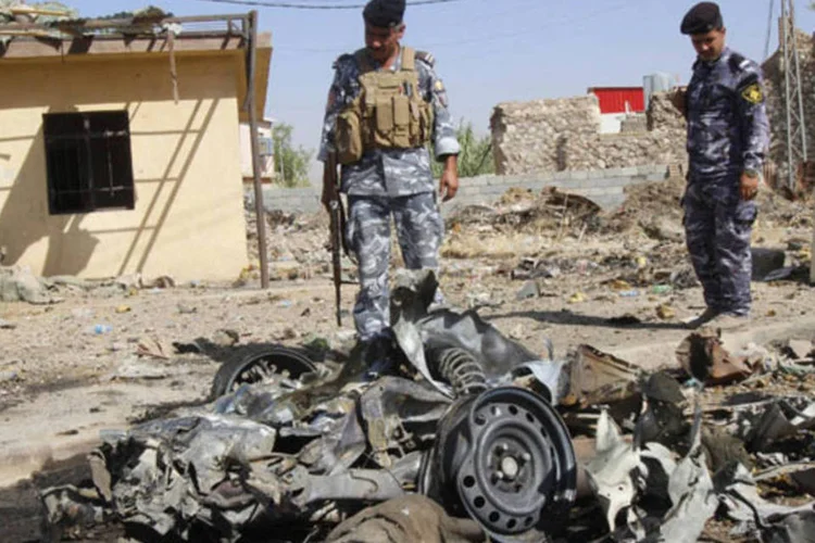Policial inspeciona os destroços de um carro após um ataque a bomba em Kirkuk, 250 km ao norte de Bagdá, no Iraque (Ako Rasheed/Reuters)