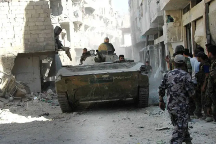 
	Fo&ccedil;as leais ao presidente Bashar al-Assad s&atilde;o vistos no bairro de Khaldia, em Homs, na S&iacute;ria: tanto o regime de Damasco como os rebeldes s&iacute;rios se acusaram de usar armas qu&iacute;micas
 (SANA/Divulgação via Reuters)