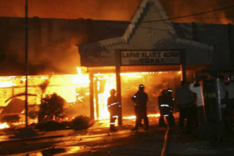 Bombeiros e policiais em frente a prisão de Tanjung Gusta em chamas, provocado pelos próprios presos, em Medan, na Indonésia (Reuters)
