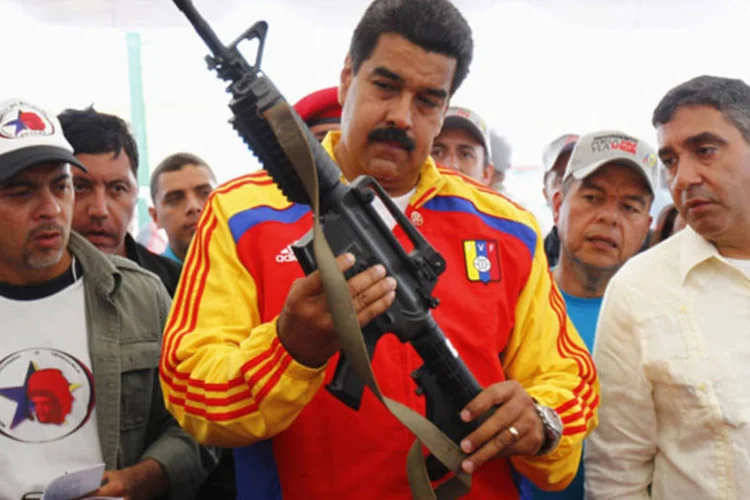 Nicolás Maduro, presidente da Venezuela, segura uma arma durante destruição pública de armamentos confiscados, em Caracas (Carlos Garcia Rawlins/Reuters)