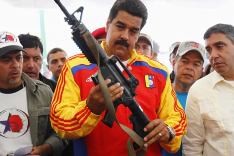 
	Nicol&aacute;s Maduro segura uma arma durante destrui&ccedil;&atilde;o p&uacute;blica de armamentos confiscados, em Caracas
 (Carlos Garcia Rawlins/Reuters)