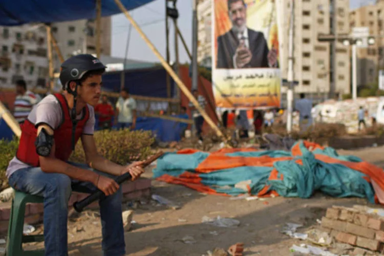 Apoiados do presidente desposto Mohamed Mursi monta guarda na entrada da área sitiada em torno da mesquita Raba' al-Adawya, em Cairo (Asmaa Waguih/Reuters)