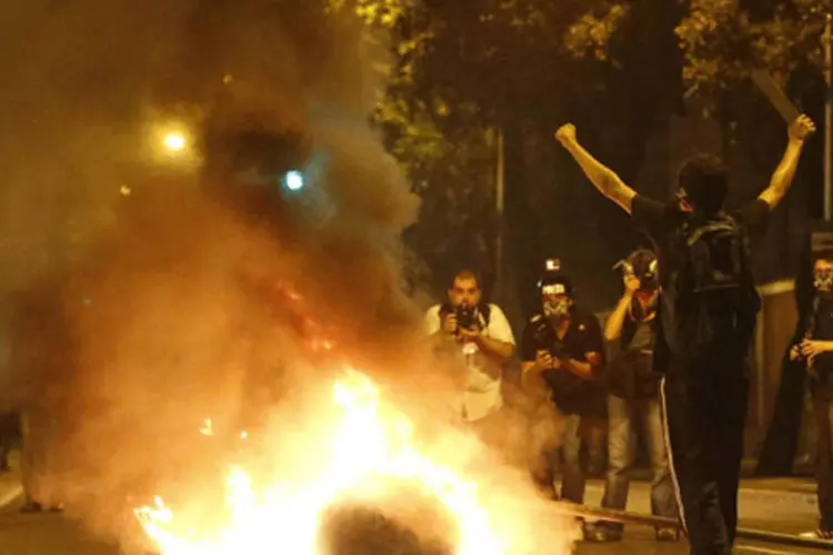 Manifestante ao lado de um telefone público em chamas durante os protestos contra o governador Sergio Cabral, próximo do Palácio Guanabara (Sergio Moraes/Reuters)