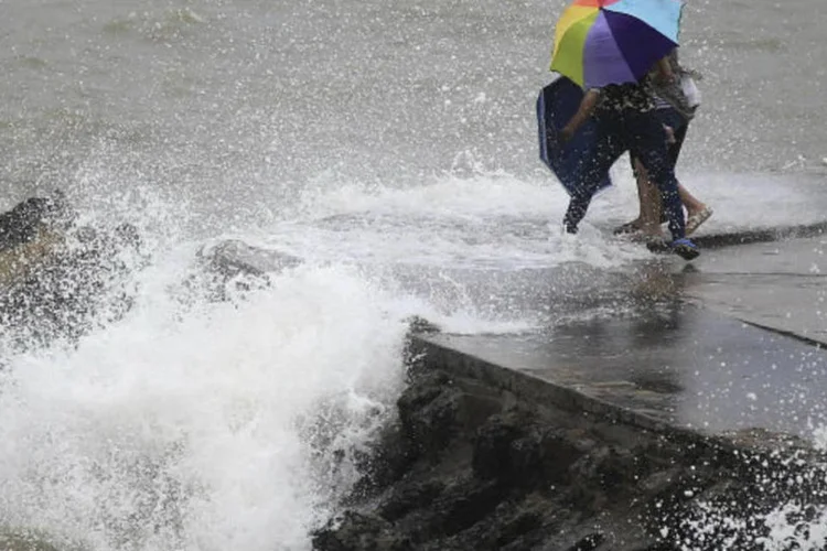 
	Pessoas fogem das ondas causadas pelo tuf&atilde;o Utor em Haikou, nas Filipinas, onde&nbsp;deixou pelo menos tr&ecirc;s pessoas mortas
 (China Daily/Reuters)