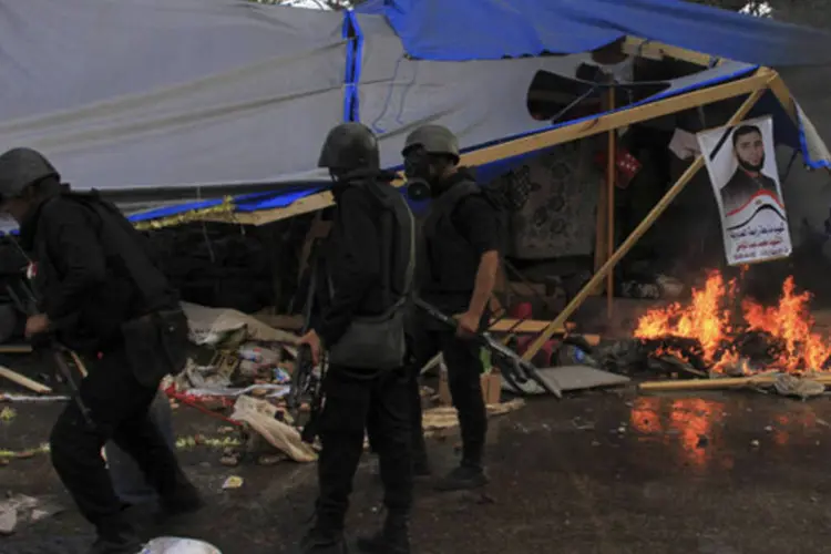 Tropa de choque da polícia limpa a área em que apoiadores do presidente Mohamed Mursi mantinham um acampamento, na praça Rabaa Adawiya, no Cairo (Reuters)