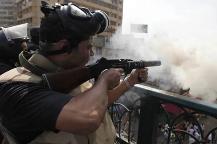 Policial das tropas de choque dispara gás lacrimogêneo contra membros da Irmandade Muçulmana e apoiadores do presidente deposto Mohamed Mursi, no Cairo, Egito (Mohamed Abd El Ghany/Reuters)