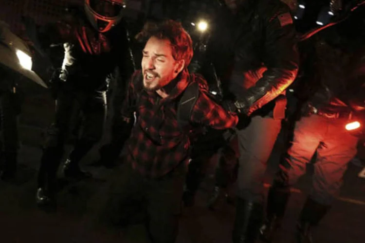 Suposto manifestante do grupo Black Bloc é levado pela polícia após confronto durante protesto contra o governador Geraldo Alckmin (Nacho Doce/Reuters)