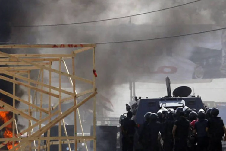 Policiais da tropa de choque se reúnem atrás de um veículo militar durante manifestação na praça Rabaa Adawiya, em Cairo (Amr Abdallah Dalsh/Reuters)