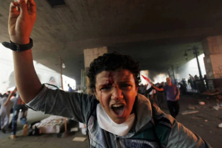 
	Jovem membro da Irmandade Mu&ccedil;ulmana grita palavras de ordem: mais de 700 pessoas morreram, a maioria de simpatizantes de Mursi, em quatro dias de viol&ecirc;ncia
 (REUTERS/Amr Abdallah Dalsh)