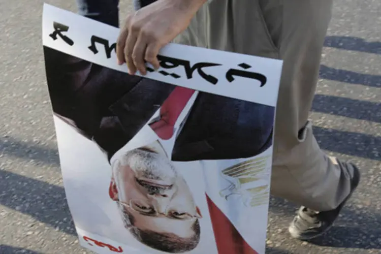 Manifestante segura um poster do presidente deposto Mohamed Mursi durante protesto em Cairo (Youssef Boudlal/Reuters)