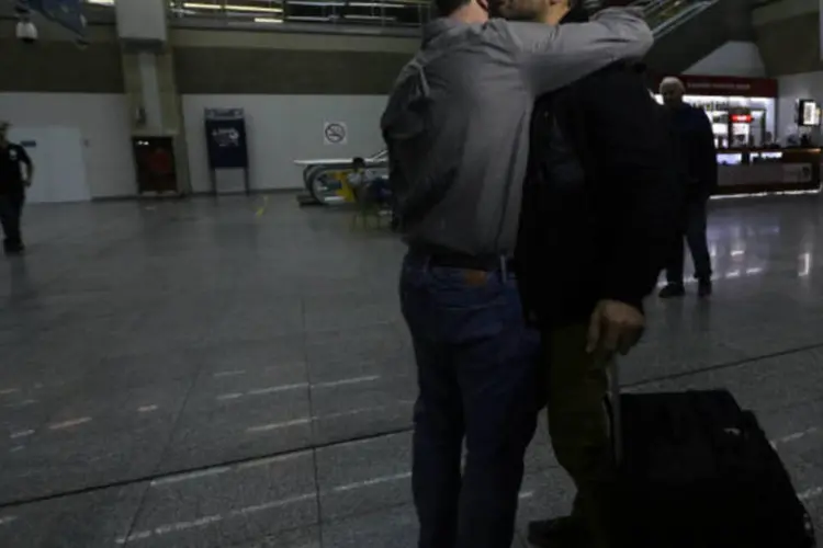 
	Jornalista Glenn Greenwald abra&ccedil;a seu parceiro David Miranda em sua chegada ao Rio de Janeiro ap&oacute;s ter ficado detido durante nove horas no aeroporto de Londres
 (Ricardo Moraes/Reuters)