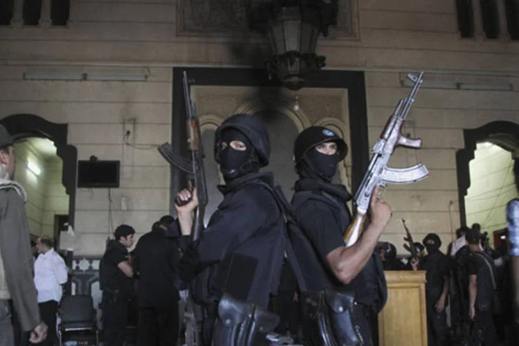 Policiais montam guarda dentro da mesquita al-Fath, onde apoiadores do presidente deposto do Egito Mohamed Mursi trocaram tiros com as forças de segurança, no Cairo (Muhammad Hamed/Reuters)