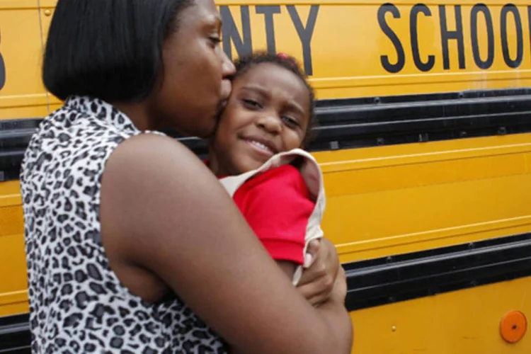Mãe abraça sua filha após tiroteio em uma escola primária no subúrbio de Atlanta nesta terça (Tami Chappell/Reuters)