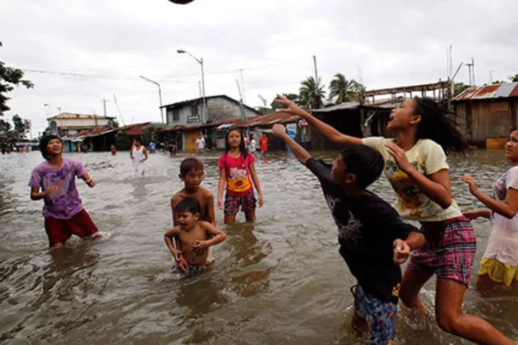 
	Jovens jogam v&ocirc;lei em regi&atilde;o alagada nas Filipinas: mais de 1,9 milh&atilde;o de pessoas ficaram desabrigadas&nbsp;
 (Erik De Castro/Reuters)