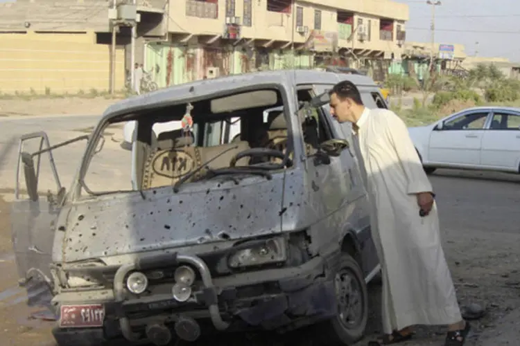 
	Morador olha um ve&iacute;culo danificado ap&oacute;s ataque no Iraque: pa&iacute;s tem registrado graves incidentes entre sunitas e xiitas
 (Reuters)