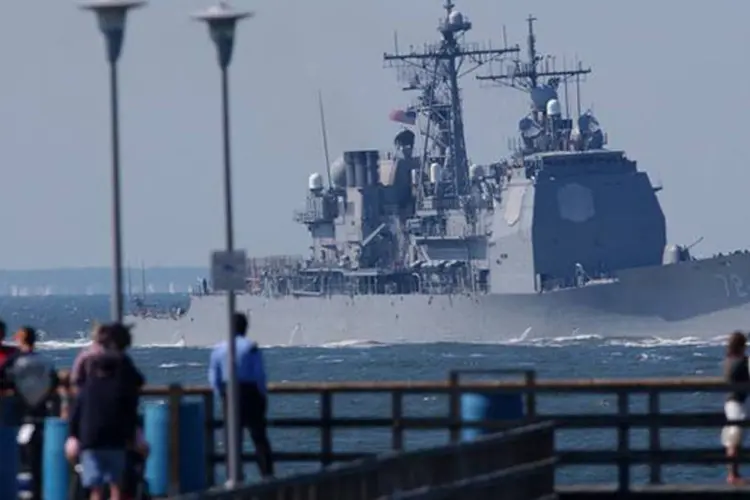 Turistas observam o navio de guerra cruzador de mísseis USS Mahan partindo para o oceano Atlântico, perto de Virginia Beach (Chip East cme/GAC/Reuters)