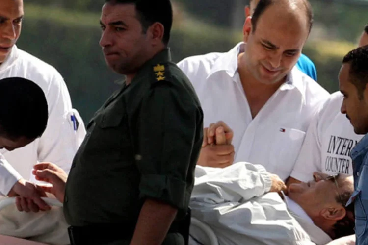 Soldados egípcios e médicos transportam o ex-presidente Hosni Mubarak após participar de uma audiência na periferia de Cairo (Muhammad Hamed/Reuters)