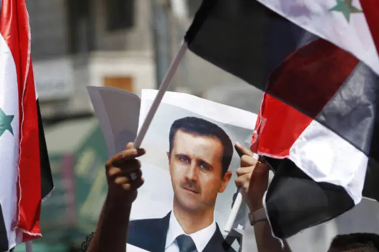 
	Manifestante palestino ergue cartaz de Bashar al-Assad durante protesto contra pontenciais ataques sobre a S&iacute;ria: EUA teme repres&aacute;rias
 (Mohamad Torokman/Reuters)