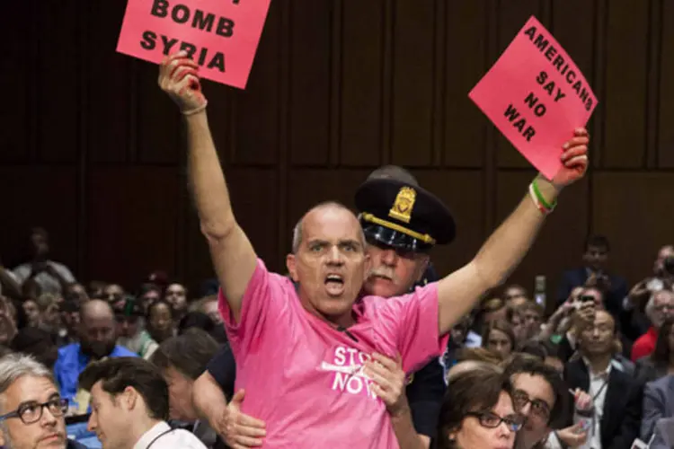 Manifestante segura uma placa contra uma intervenção militar na Síria durante audiência na Comissão de Relações Exteriores do Senado dos EUA (Joshua Roberts/Reuters)