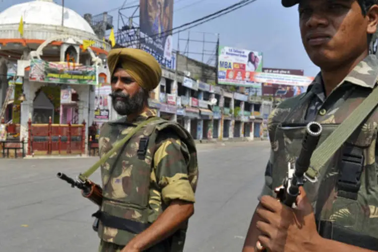 Soldados montam guarda em uma rua deserta após um toque de recolher na cidade de Muzaffarnagar, ao norte de Nova Délhi, na Índia (Stringer/Reuters)
