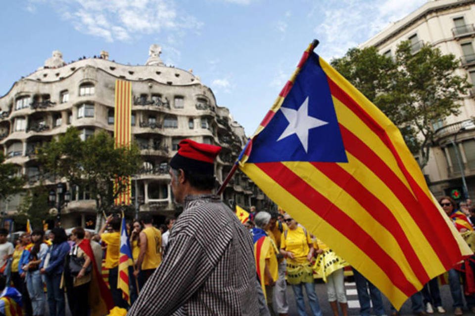 
	Homem com a bandeira pr&oacute;-independ&ecirc;ncia da Catalunha: no dia 8 de abril, o Parlamento catal&atilde;o pedir&aacute; ao Congresso espanhol a transfer&ecirc;ncia das compet&ecirc;ncias para organizar um referendo (Albert Gea/Reuters)