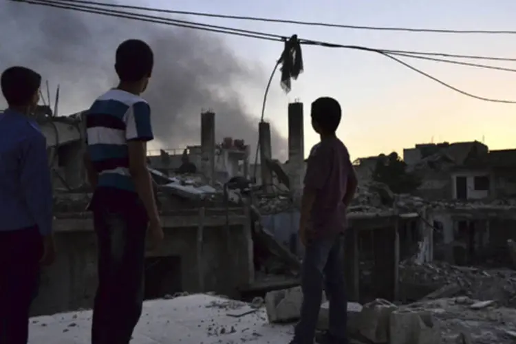 Fumaça de um tanque do governo sírio que os ativistas do Exército Livre da Síria dizem ter sido destruído por eles, em Ghouta (Bassam Khabieh/Reuters)