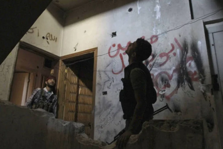 Membro da brigada Shohadaa Badr, que opera sobre os comandos do Exército Livre da Síria, em um prédio danificado em Alepo (Muzaffar Salman/Reuters)