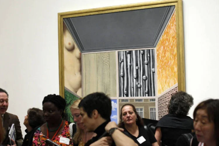 Visitantes perto de uma pintura de 1937 do artista René Magritte, durante a abertura da mostra "Magritte: O Mistério do Ordinário, 1926-1938" no MoMa (Joshua Lott/Reuters)