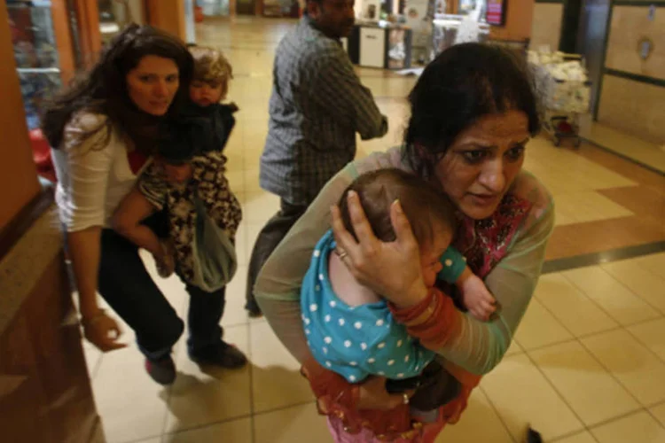 Mulheres carregando crianças são retiradas de shopping center em Nairóbi, no Quênia (Goran Tomasevi/Reuters)