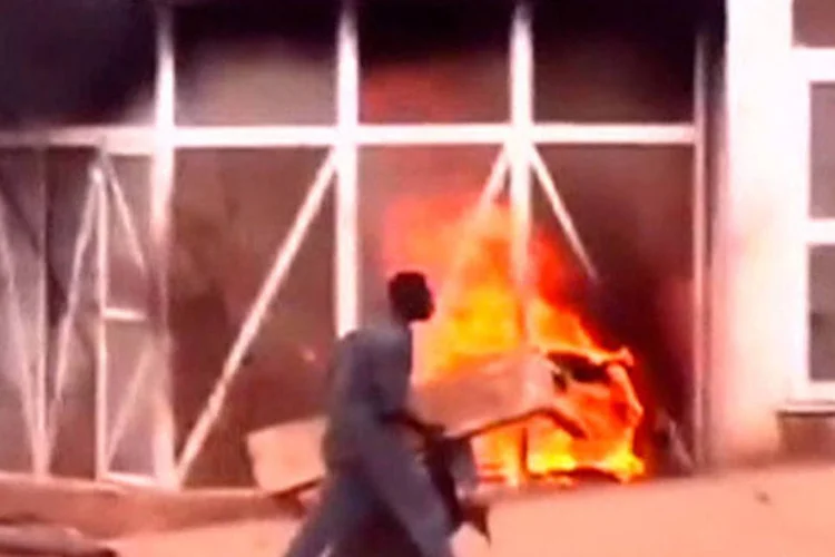 Um homem passa por uma estação de petróleo em chamas durante protesto contra corte de em subsídios de combustíveis no Sudão (Kidintakar Radio Station/Storyful/via Reuters TV)