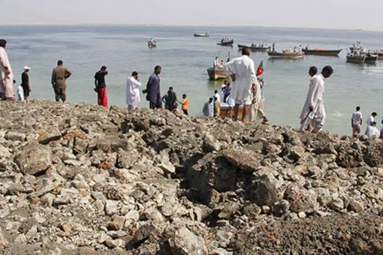 
	Pessoas chegam de barco a uma ilha que surgiu durante o terremoto do Paquist&atilde;o: 40 mil casas ficaram destru&iacute;das
 (Stringer/Reuters)