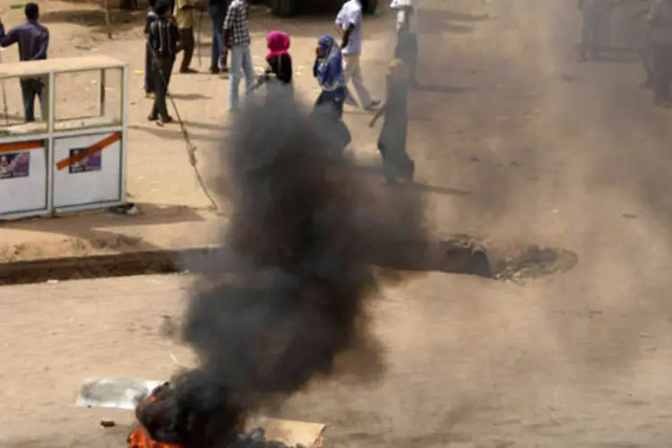 Pneus pegando fogo em uma rua durante protestos contra os cortes de subsídio do combustível em Cartum, Sudão (Reuters)