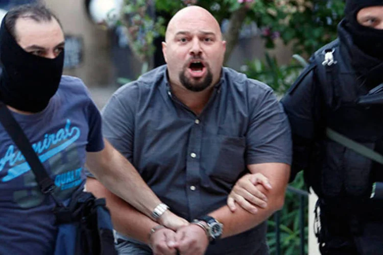 
	Membro do partido de extrema direita Amanhecer Dourado &eacute; preso:&nbsp;di&aacute;logo vazado revelou um di&aacute;logo entre o comando da pol&iacute;cia e a patrulha presente no local
 (Giorgos Moutafis/Reuters)